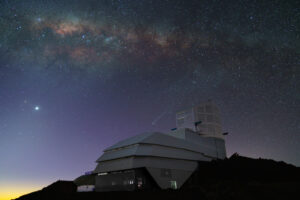 El cielo nocturno deslumbra sobre el Observatorio Rubin en esta foto de octubre de 2024. La Vía Láctea se extiende sobre nosotros en la luz menguante del atardecer. Venus brilla intensamente a la izquierda, mientras que el cometa C/2023 A3 (Tsuchinshan-ATLAS) aparece justo encima del observatorio en el centro.